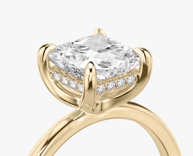 Princess cut diamond engagement ring in yellow gold with hidden halo and detailed claw setting.