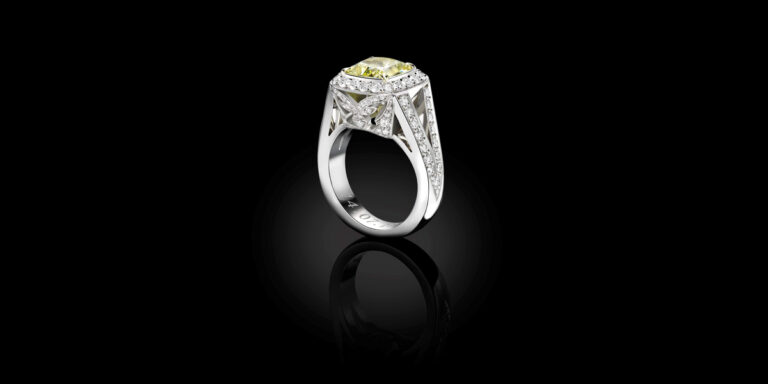 Bespoke cushion cut fancy yellow diamond engagement ring with diamond halo and pavé set shoulders, handcrafted by Icecool Diamonds in Hatton Garden.