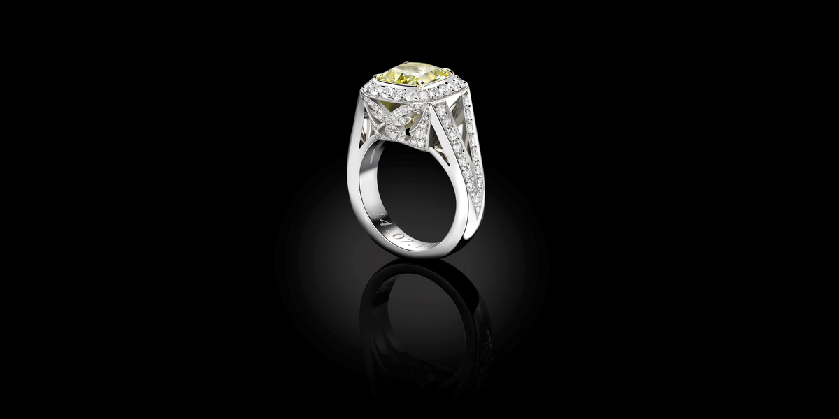 Bespoke cushion cut fancy yellow diamond engagement ring with diamond halo and pavé set shoulders, handcrafted by Icecool Diamonds in Hatton Garden.